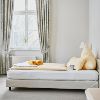 Ein gemütliches Bett in einem ruhigen Zimmer der psychosomatischen Klinik, das zur Entspannung einlädt.